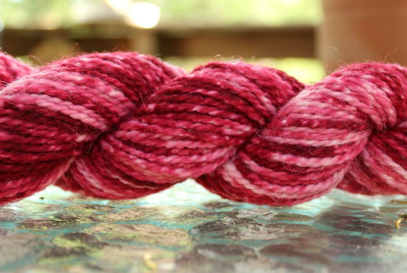 image of a skein of yarn dyed in shades of red