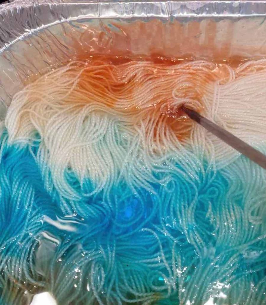 image of orange wool dye being stirred